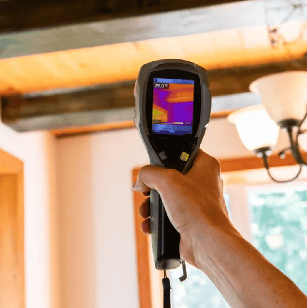 technician holding an air quality reader to test air quality inside a home